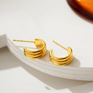 Orecchini a cerchio triplo a C in oro 18K su piedistallo geometrico minimalista