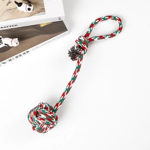Detailed view of red, green and white woven cotton dog rope ball with a durable handle