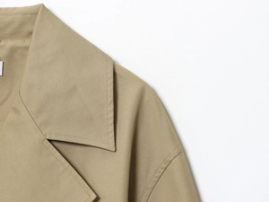 Dettaglio del colletto a rever e del tessuto in twill di un trench kaki da donna