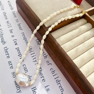 Elegant baroque freshwater pearl necklace on a vintage wooden box and poetic background