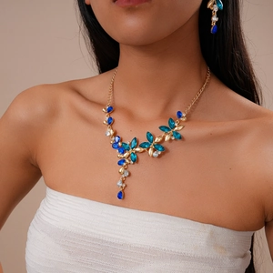 Détail du parure de bijoux florale avec cristaux bleus portés par un mannequin