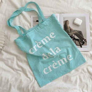 Detailansicht der minzgrünen Canvas-Einkaufstasche mit weißem creme dela creme Aufdruck
