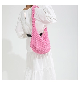 Detail of vibrant pink bubble textured hobo bag featuring soft pleated fabric and zip closure