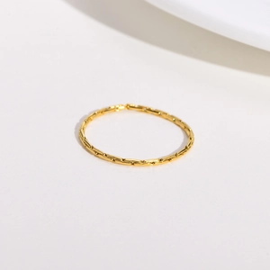 Detail showing the textured golden stainless steel minimalist ring with bamboo-like pattern