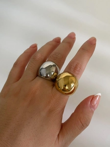 Close-up of wide polished 18K gold and silver chunky rings on a hand for minimalist style