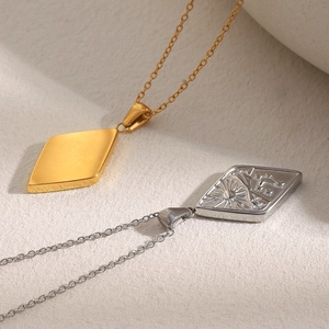 Dettaglio di collane a rombo placcate oro 18K e argento con incisioni di sole e stelle