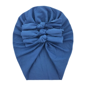 Detail of blue cotton baby turban hat featuring three soft decorative bows on front