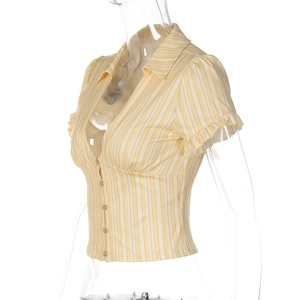 Détail de la chemise rayée jaune et blanche avec poignets à volants et boutons