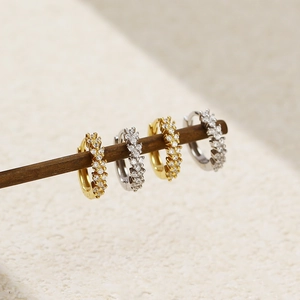 Detail of s925 silver hoop earrings in gold and silver finish with pavé set crystals