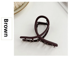 Macro shot of dark brown matte hair claw clip with strong metal spring and rounded teeth