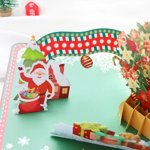 3D pop-up Christmas card featuring Santa Claus, snow house, and a festive pine tree