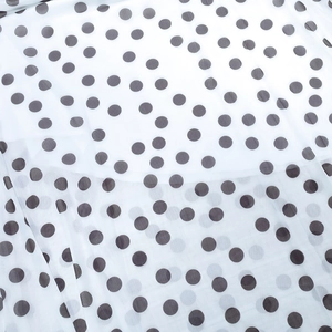Close-up of lightweight white polka dot mesh fabric with soft translucent texture