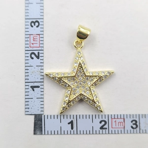 Détail du pendentif étoile dorée montrant les dimensions de 2,5 cm avec un ruban