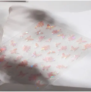 Detailed macro view of laser holographic butterfly and cherry blossom nail art stickers