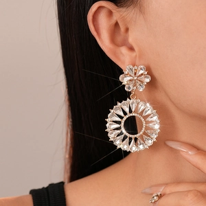 Elegant gold flower hoop earrings with crystal rhinestones on a female model
