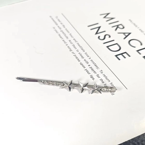 Exquisite silver star and moon hair clip with rhinestones on a vintage book page