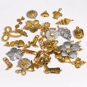 Flat lay of gold and silver stainless steel charms featuring flowers and star patterns