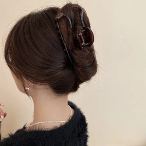 Detail of a leopard print claw clip styled in a classic French twist hairstyle