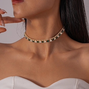 Close-up of double-layer gold necklace with emerald green and white square zircon stones