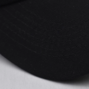 Close-up of black cotton baseball cap brim with detailed six-row reinforced stitching