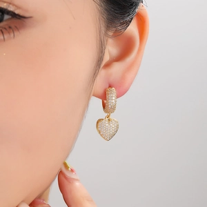 Elegant gold-plated heart earrings with sparkling small crystals worn by model