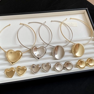 Detailed set of gold and silver heart and oval jewelry in a black and white gift box