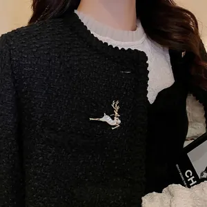 Élégante broche renne dorée avec perle et nacre sur une veste en tweed noir