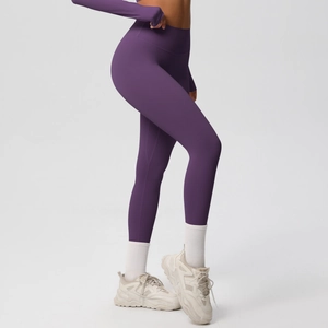 Side view of dark purple high-waisted yoga leggings showing elastic fit and slim silhouette