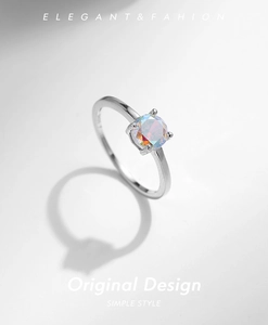 Macro shot of minimalist silver S925 ring with iridescent round zircon and four-prong setting