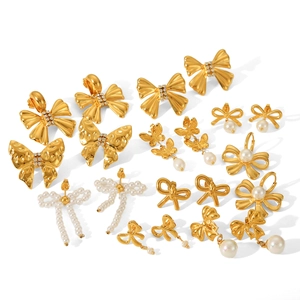 French style 18K gold plated bow earrings set with pearls and rhinestones on white