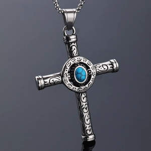 Detailed view of vintage silver cross pendant with turquoise stone and ornate carvings