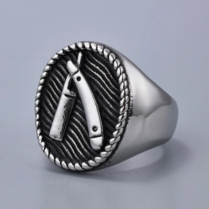 Detail view of silver stainless steel ring with black embossed razor blade cross design