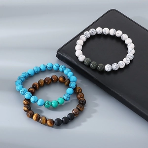 Detailed close-up of 8mm beaded bracelets with tiger eye and matte agate stone textures