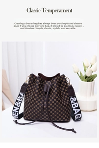 Close-up of vintage brown drawstring bucket bag with monogram pattern and wide strap