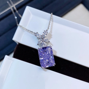 Macro shot of a purple square-cut crystal pendant on a silver necklace in a gift box