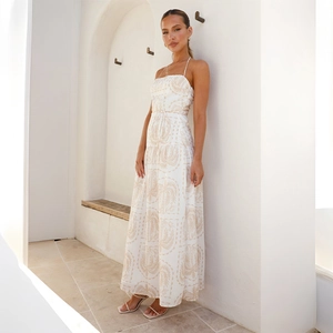 Détail de robe d'été longue crème avec imprimé palmiers et jupe à plusieurs niveaux