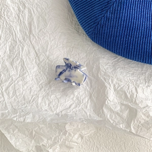 Detail of blue and white marble-patterned hair claw clip with acetate clouds effect