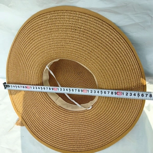 Wide brim straw sun hat with woven texture and white chin strap for beach vacation