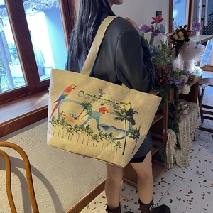 Linen tote bag with tropical parrot print and Cartagena text on a model's shoulder