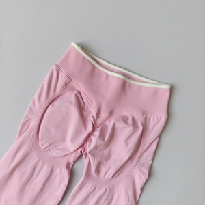 Flat lay detail of pink scrunch yoga leggings with ribbed high waist and support texture