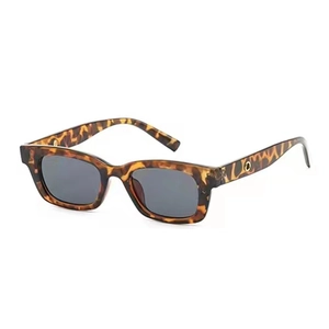 Detail of vintage tortoiseshell sunglasses with small rectangular frames and gold hinge accents