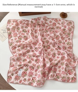 Detail of pink floral cotton scarf featuring delicate lace edges on a white table