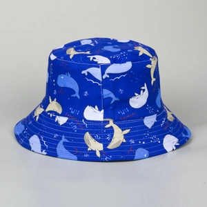 Detailed pattern of a navy blue bucket hat featuring cartoon whale prints and text