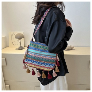 Detail of ethnic shoulder bag featuring colorful geometric patterns and decorative tassels