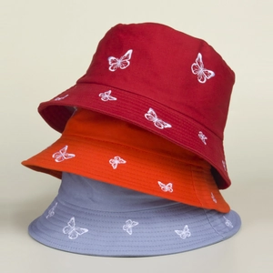 Detailed close-up of embroidered butterfly patterns on colorful cotton bucket hats