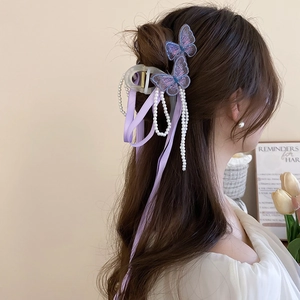 Pince à cheveux élégante en ruban violet avec perles et papillons brodés portée sur cheveux
