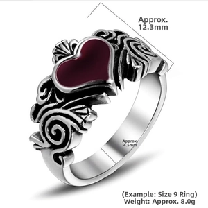Detail view of gothic heart ring with red enamel inlay and intricate flame engravings