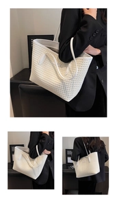 Detail of white woven texture tote bag with slim shoulder strap worn on professional blazer