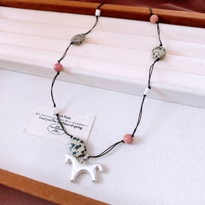 Vue détaillée du pendentif cheval en argent mat avec perles mouchetées en pierre dalmate