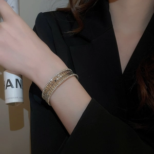 Detail of wide gold plated cuff bracelet with sparkling crystal stones on model